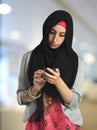 Young Islamic businesswoman messaging on the phone