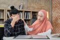 Young Islamic female comforts male business colleague