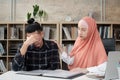 Young Islamic female comforts male business colleague