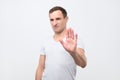 Young italian man shows stop timeout or refusal sign with hand Royalty Free Stock Photo