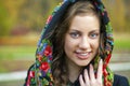 Young Italians in a beige coat and knit a scarf on her head