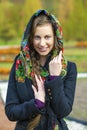 Young Italians in a beige coat and knit a scarf on her head