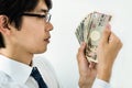 Young Japanese businessman counting money. Holding a stack of Japanese yen banknotes. Royalty Free Stock Photo