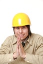 Young Japanese construction worker folding his hands in prayer Royalty Free Stock Photo