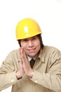 Young Japanese construction worker folding his hands in prayer Royalty Free Stock Photo