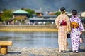 Young Japanese Girls Wearing Traditional Geisha`s Kimono In Front of Pond in Kyoto, Japan Royalty Free Stock Photo