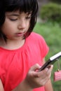 Young Japanese-Russian girl playing with cellphone Royalty Free Stock Photo