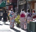 Young Japanese woman dressed in Kimono walking in market, with back to camera