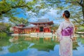 Young Japanese Woman in Traditional Kimono Dress at the Phoenix Hall of Byodo-in Temple in Kyoto, Japan Royalty Free Stock Photo