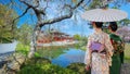 Young Japanese Woman in Traditional Kimono Dress at the Phoenix Hall of Byodo-in Temple in Kyoto, Japan