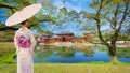 Young Japanese woman in a traditional Kimono dress with the Phoenix Hall of Byodo-in Temple in Kyoto Royalty Free Stock Photo