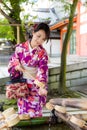 Young japanese woman use of bamboo ladle in water fountain Royalty Free Stock Photo