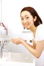 Young Japanese woman washes her face in lavatory Royalty Free Stock Photo