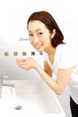 Young Japanese woman washes her face in lavatory Royalty Free Stock Photo