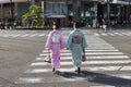 young Japanese women in traditional Kimono crossing a street in Kyoto, Japan