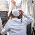 A young Jewish Hasid boy in a traditional headdress of a kippah and with long payos