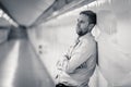 Young businessman crying abandoned lost in depression leaning on wall alone in subway tunnel Royalty Free Stock Photo