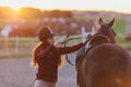 Young jockette preparing her horse for riding. Royalty Free Stock Photo