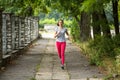 Young jogging woman running through the summer park road. Royalty Free Stock Photo