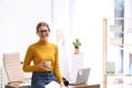 Young journalist with coffee at workplace in office