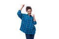 young joyful caucasian curly lady dressed in a plaid shirt smiling on a white background with copy space Royalty Free Stock Photo