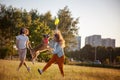 Young joyful couple playing with their dog in the park with plate of frisbee, dog sport and training concept Royalty Free Stock Photo