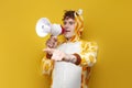 young joyful guy in funny children\'s giraffe pajamas speaks into megaphone and points his hand to the side