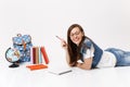 Young joyful happy woman student in denim clothes, glasses holding pencil notebook lying near globe, backpack, school Royalty Free Stock Photo