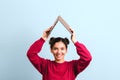 Young joyful woman student with beautiful smile holding an opened laptop over her head in form of roof. investing in education Royalty Free Stock Photo