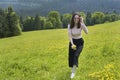 Young joyful woman is walking on a flower meadow. Summer sunny d Royalty Free Stock Photo
