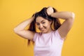 Young joyous girl ruffles long hair on head.