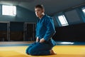 Young judo fighter in kimono posing comfident in the gym, strong and healthy