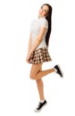 Young jumping girl in plaid skirt