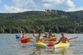 Waving cheerful friends in kayaks summer