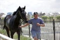 Young Kazakh man is taking a black horse after racing