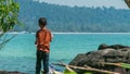 Young Khmer boy is looking at the ocean