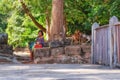 A young Khmer girl sits on ancient stone blocks and sells souvenirs