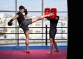 Kickboxing fighter hitting pads with trainer