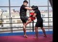 Kickboxing fighter hitting pads with trainer