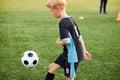 Young kid boy training with ball alone in stadium Royalty Free Stock Photo