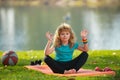 Young kid practicing yoga outdoors, lotus pose yoga. Harmony and meditation concept. Healthy lifestyle. Kid meditating Royalty Free Stock Photo