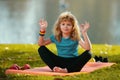 Young kid practicing yoga outdoors, lotus pose yoga. Harmony and meditation concept. Healthy lifestyle. Kid meditating Royalty Free Stock Photo