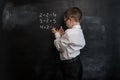 Young kid`s solving elementary maths expression. Back to school concept. Smart and clever preschool boy. Royalty Free Stock Photo