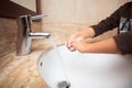 Young kid washing and rubbing his hands and fingers with soap