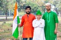 Young kids and boy of different age and different religion hearing tricolor dress and holding Indian National flag. Royalty Free Stock Photo