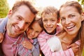 Young kids hugging parents outdoors, close up portrait