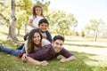 Young kids and parents lying in pile on the grass, portrait Royalty Free Stock Photo