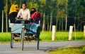 Young kids riding a three wheelers in an urban road