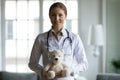 Young kind female pediatrician holding toy in hands.