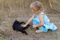 Young kind girl and black cat.